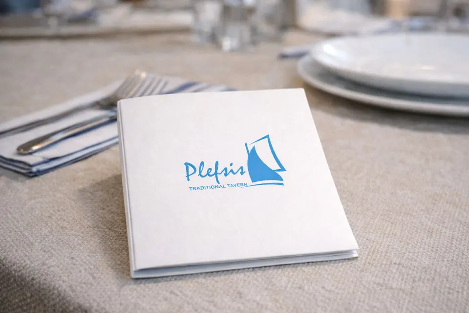 Λευκό έντυπο menu παραδοσιακής ταβέρνας πάνω σε τραπέζι